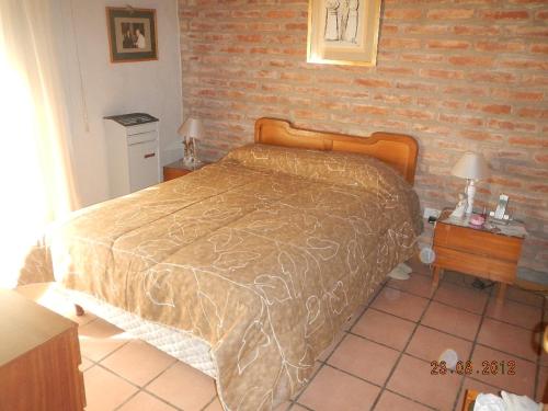 1 dormitorio con cama y pared de ladrillo en Complejo Duque en Puerto Madryn