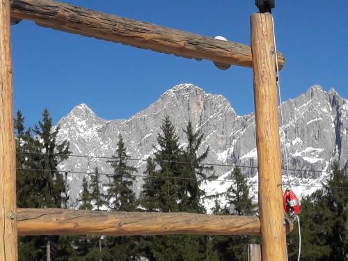 a view of a mountain through a wooden window at Appartement "Haus Lisa" in Ramsau am Dachstein in Ramsau am Dachstein