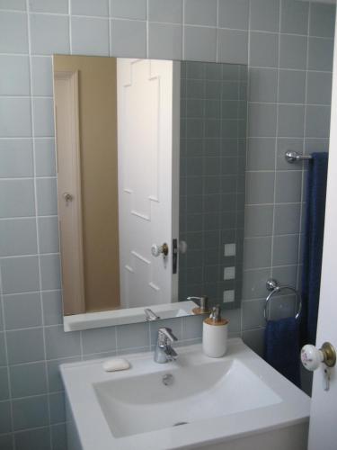 y baño con lavabo blanco y espejo. en Yourpenthouseinmadeira en Funchal