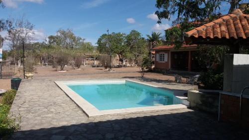 a swimming pool in a yard next to a house at Casa de Campo com piscina in Gravatá