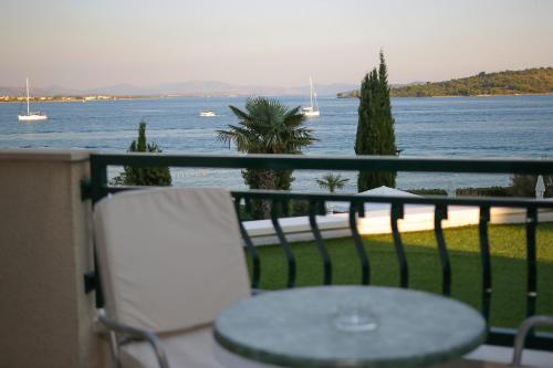 a table on a balcony with a view of the water at Hotel Villa Radin in Vodice