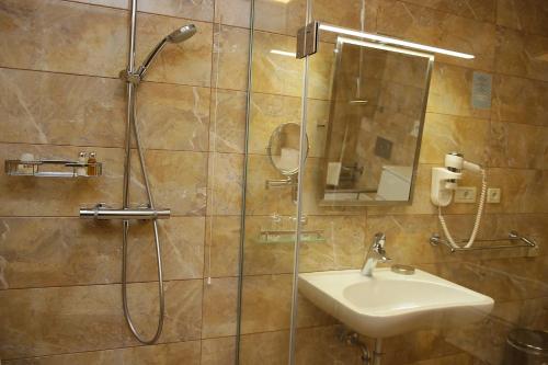a bathroom with a shower and a sink at Hotel Villa Radin in Vodice