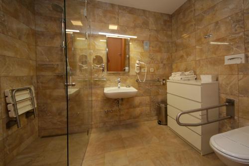 a bathroom with a shower and a sink and a toilet at Hotel Villa Radin in Vodice