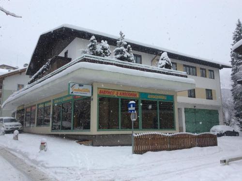 a building with snow on the top of it at Gadenstätter Apartments in der City in Zell am See