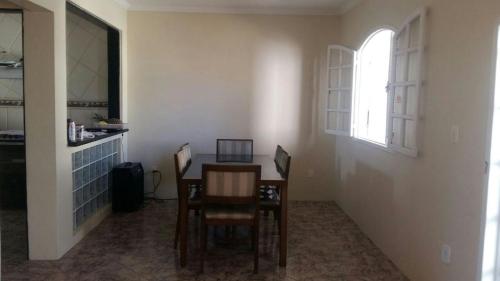 comedor con mesa, sillas y ventana en Casa de Temporada no Centro de Cabo Frio, en Cabo Frío