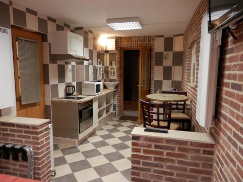 una pequeña cocina con mesa y sillas. en Hotel du Gambrinus, en Hazebrouck