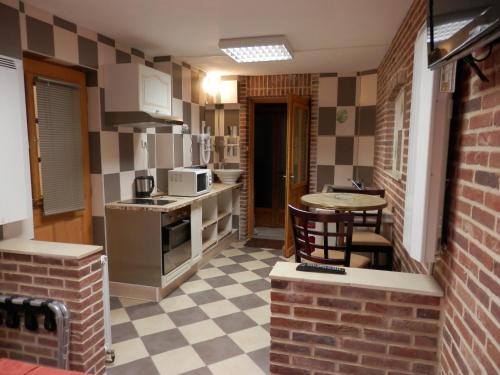 a small kitchen with a table and chairs in it at Hotel du Gambrinus in Hazebrouck