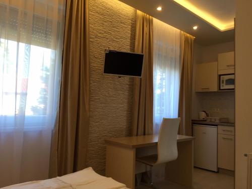 a hotel room with a desk and a television on the wall at Mosoly Szallashely in Szeged