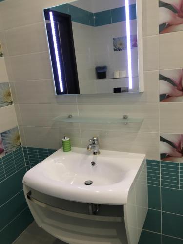 a bathroom with a white sink and a mirror at Mosoly Szallashely in Szeged