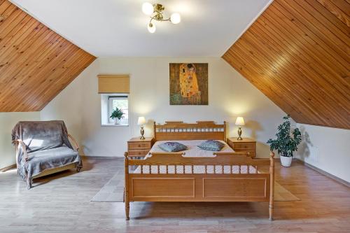 1 dormitorio con 1 cama y 1 silla en Vidos Apartamentai en Vilna