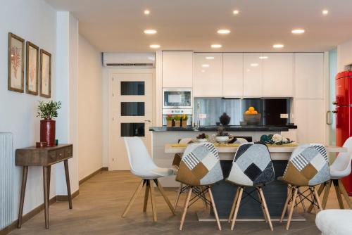 グラナダにあるGenteel Home Tablasの白いキャビネット、テーブルと椅子付きのキッチンが備わります。