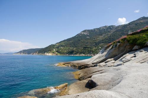 a view of the ocean from a rocky shore at Hotel Gallo Nero in SantʼAndrea