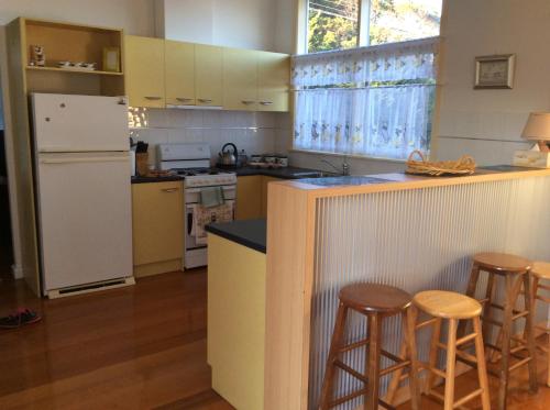 - une cuisine avec un comptoir et des tabourets dans l'établissement La Casa Della Nonna in Australia, à Lakes Entrance