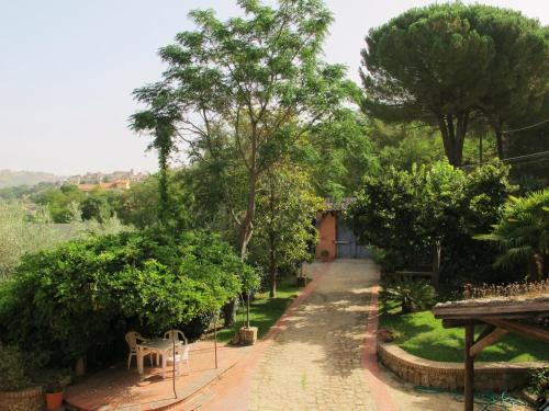 a path in a garden with trees and a building at Villa Clementine in Piazza Armerina