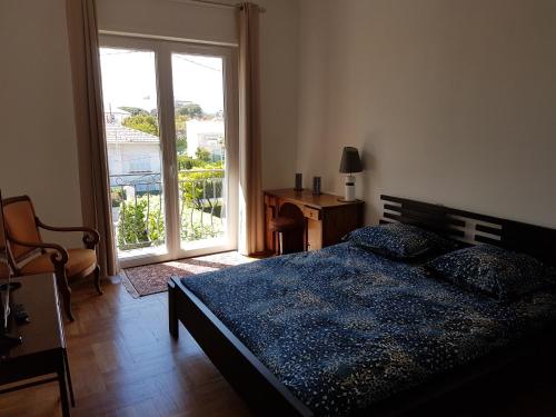 a bedroom with a bed and a window and a desk at Villa Calliste in Saint-Laurent-du-Var