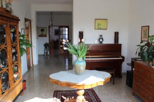 a living room with a vase on a table next to a piano at Villa Calliste in Saint-Laurent-du-Var