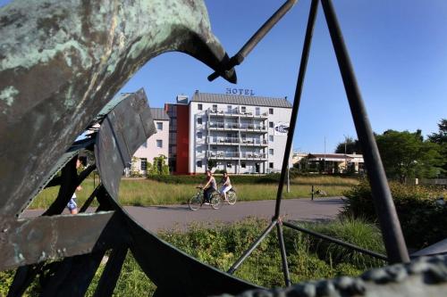 a person riding a bike in front of a building at Parkhotel Neubrandenburg in Neubrandenburg