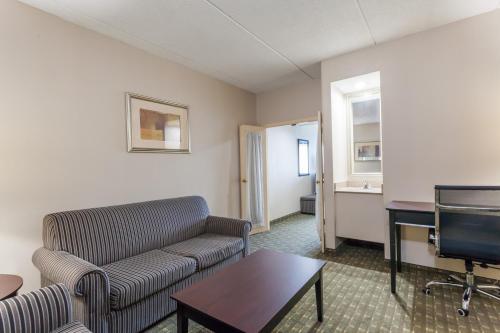 a living room with a couch and a flat screen tv at Ramada by Wyndham Newburgh/West Point in Newburgh