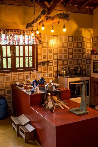 a kitchen with a counter and a stove in it at Hospedaria Vida na Roça in São Bento do Sapucaí