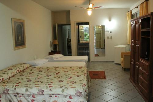 a hotel room with two beds and a bathroom at Hotel Fazenda Bela Vista in César de Pina