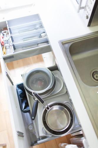 - une cuisine avec des casseroles et des poêles assises sur une cuisinière dans l'établissement Le Clos Du Perret, à Chaussan