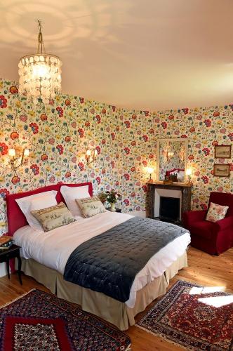 a bedroom with a large bed and a fireplace at Chateau le Quesnoy in Chevrières