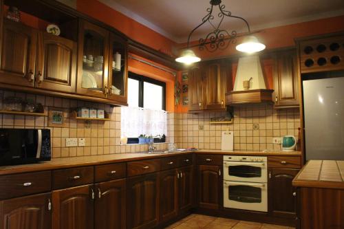 a kitchen with wooden cabinets and a white stove top oven at South Pacific Flat 2 in Marsaskala