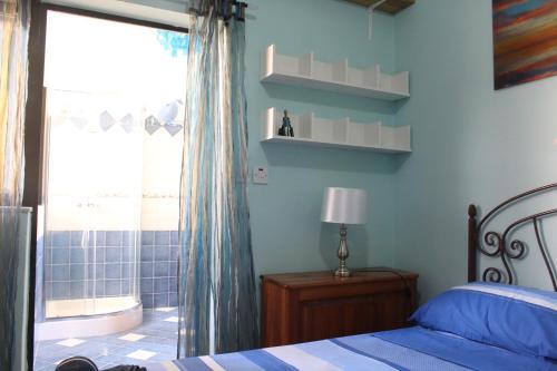 a bedroom with a bed and a bathroom with a tub at South Pacific Flat 2 in Marsaskala