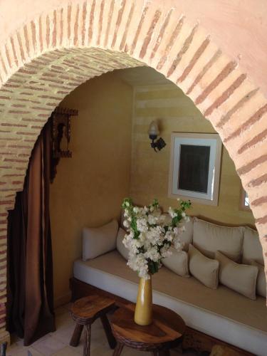 a living room with a couch and a vase of flowers at Casa Taos in Marrakech