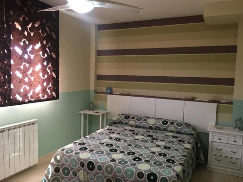 - une chambre avec un lit et un mur rayé dans l'établissement Casa Vega, à Sobradiel