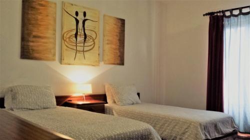 アルブフェイラにあるVila Olímpicaのベッド2台と窓が備わる客室です。