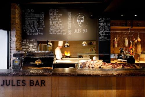 a restaurant with a bar with meat on a counter at Parkhotel Kortrijk in Kortrijk