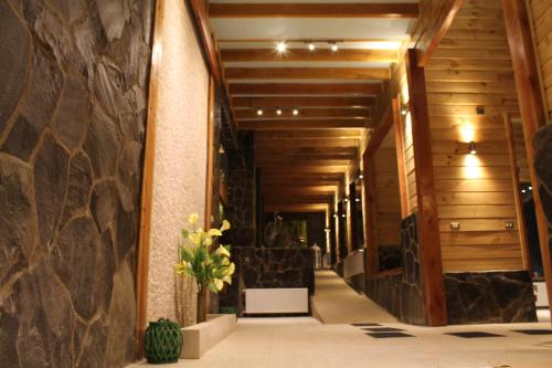 a hallway of a building with a stone wall at Cabañas Blanche Neige Wellness & SPA in Las Trancas
