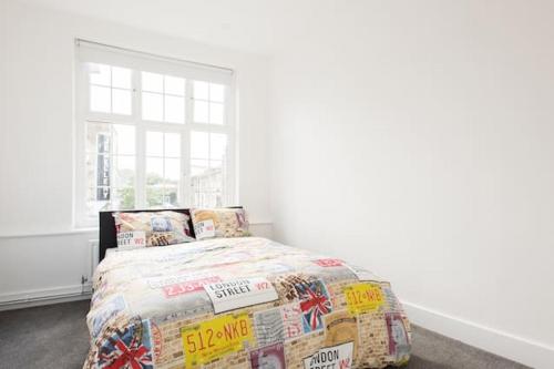ロンドンにあるKennington Apartment A/Apartmentのベッドルーム1室(ベッド1台、掛け布団、窓付)