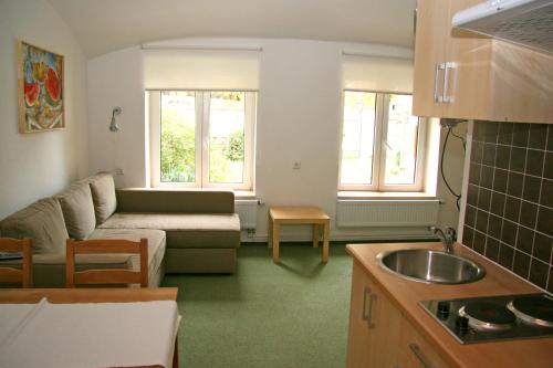 eine Küche und ein Wohnzimmer mit einem Sofa und einem Tisch in der Unterkunft Penzion Speller in Vysoký Újezd