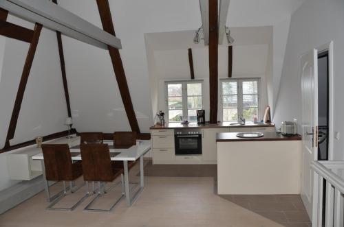 uma cozinha com mesa e cadeiras num quarto em Wohnen Unter Reet em Niebüll