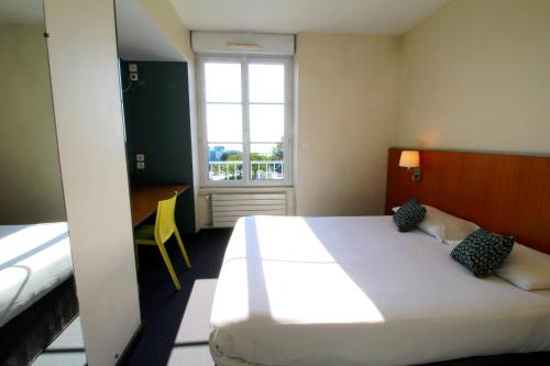 ein Schlafzimmer mit einem großen weißen Bett und einem Fenster in der Unterkunft Hotel de la Gare Brest in Brest