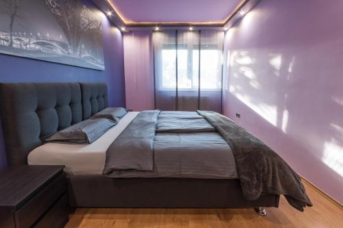 a large bed in a room with purple walls at Budapest Minimal Style - You will love it! in Budapest