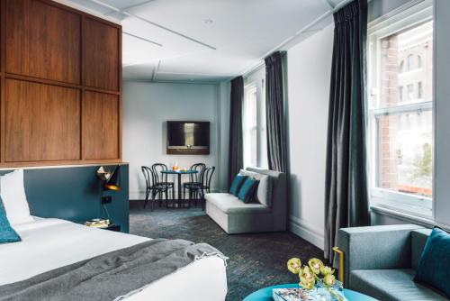 een hotelkamer met een bed, een stoel en een tafel bij Veriu Central in Sydney