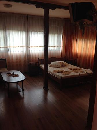 a bedroom with a canopy bed and a table at Guest House Ambrozia in Kotel