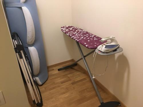 a ironing board in the corner of a room at Ontic Wellness Apartments in Tartu