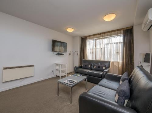 
a living room filled with furniture and a window at Bellano Motel Suites in Christchurch

