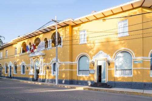 a yellow building on the side of a street at LP Los Portales Hotel Piura in Piura