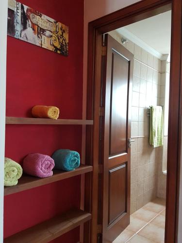 a bathroom with red walls and shelves with towels at Casa Garita Beach in Arrieta