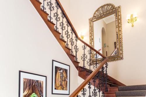 a stairway with a mirror and framed paintings at LP Los Portales Hotel Piura in Piura