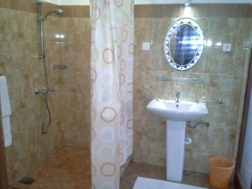 a bathroom with a sink and a shower with a mirror at White Bridge House & Resort in Aluthgama