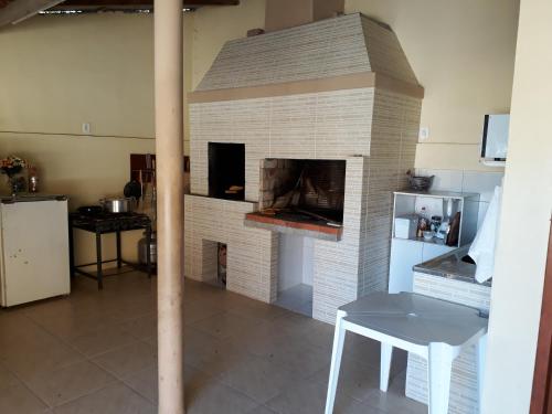 sala de estar con chimenea de ladrillo, mesa y mesa en Carpe Diem Bombinhas, en Bombinhas