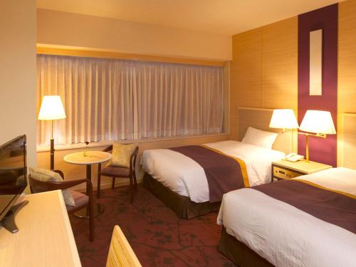 um quarto de hotel com duas camas e uma televisão em Chofu Creston Hotel em Chofu