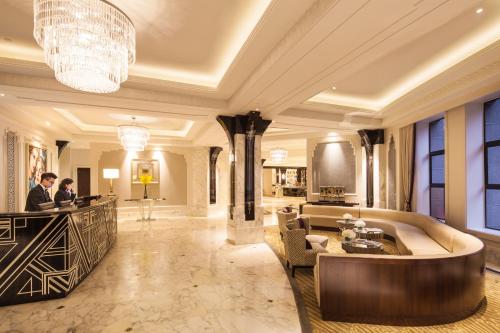 上海市にあるJinjiang Metropolo Hotel Classiq,Shanghai Bund Circleのカウンターに2名立つホテルロビー