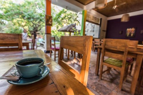 a cup of coffee sitting on a wooden table at Arjuna Homestay in Pemuteran